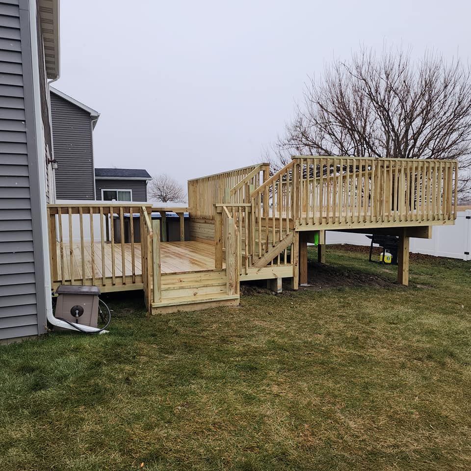 A large wooden deck is in the backyard of a house.