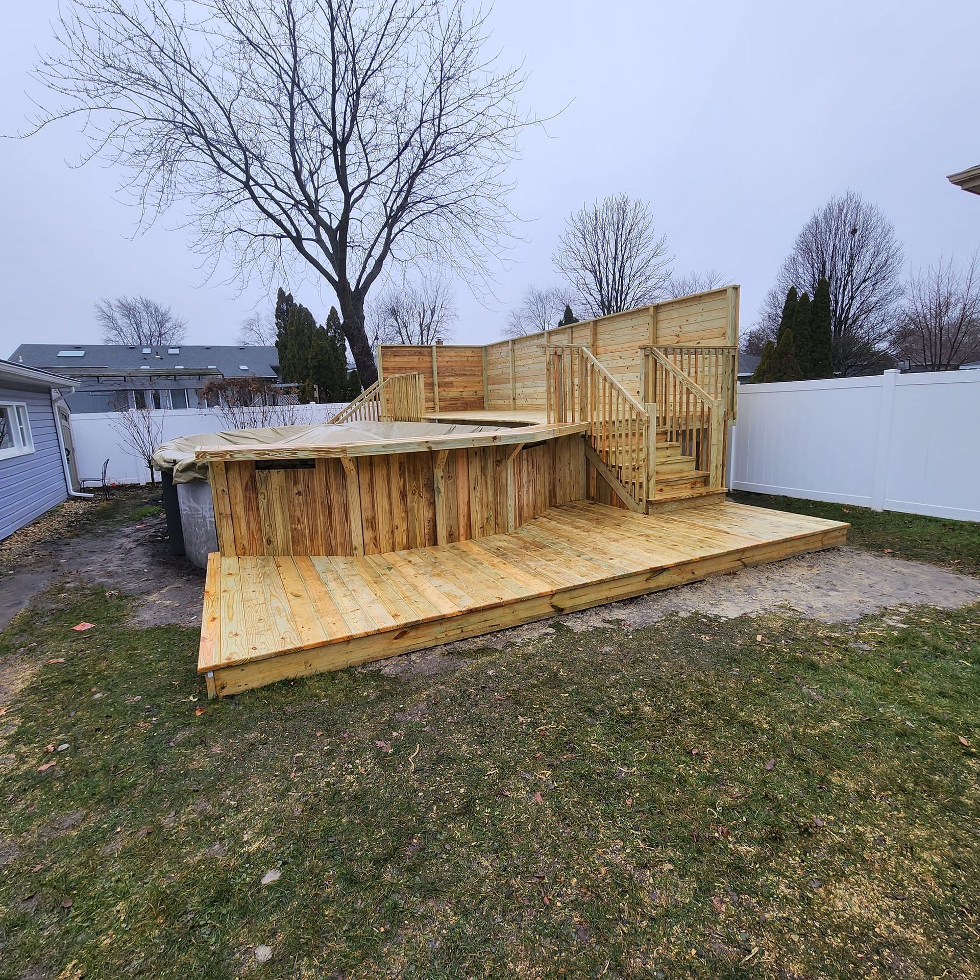A wooden deck is being built in the backyard of a house.