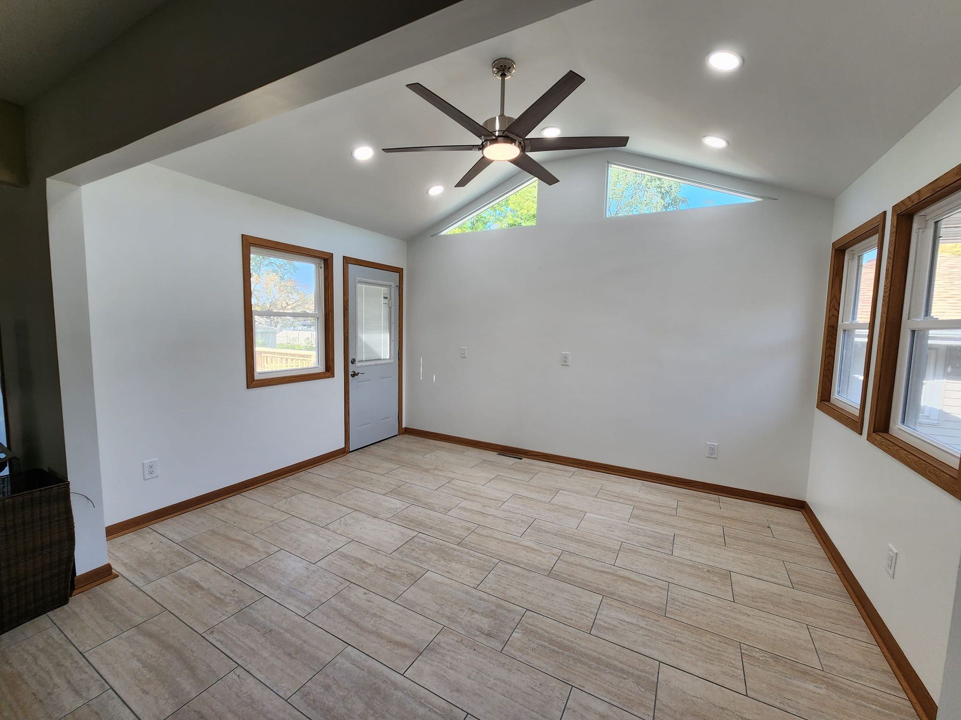 A living room with a vaulted ceiling and a ceiling fan.