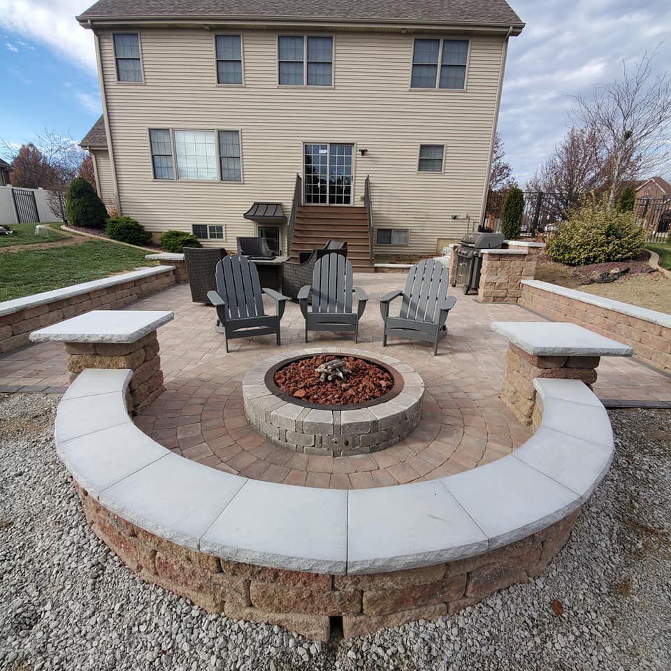 A patio with a fire pit and chairs