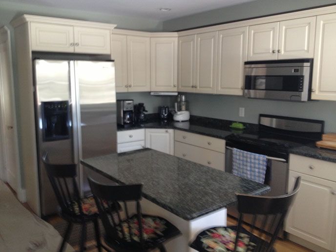 White cabinets with a dark grey granite counter