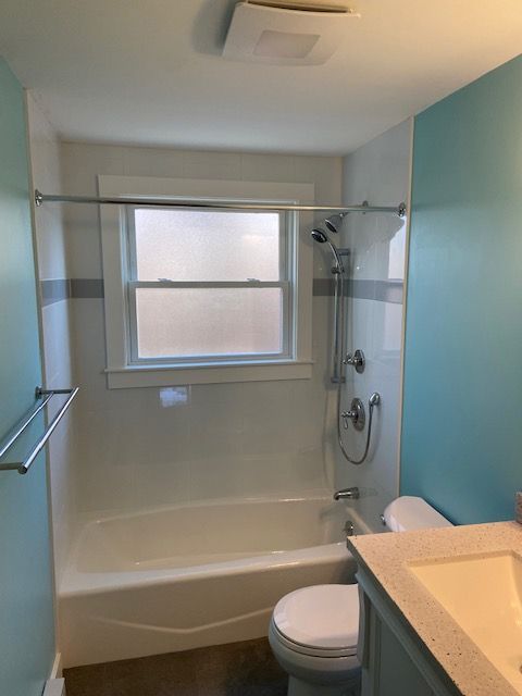 Bathroom with teal walls and a bathtub