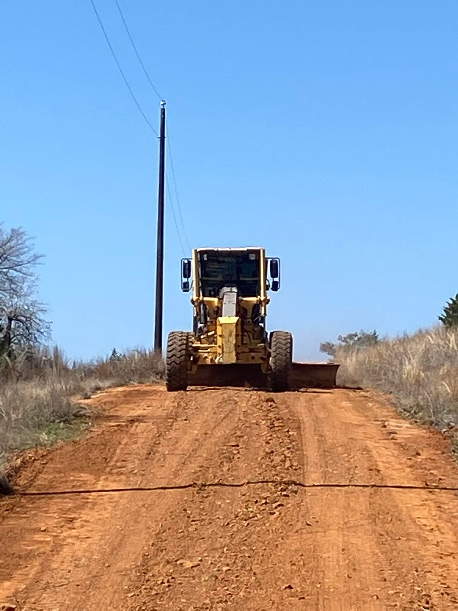 A bulldozer is driving down a dirt road.
