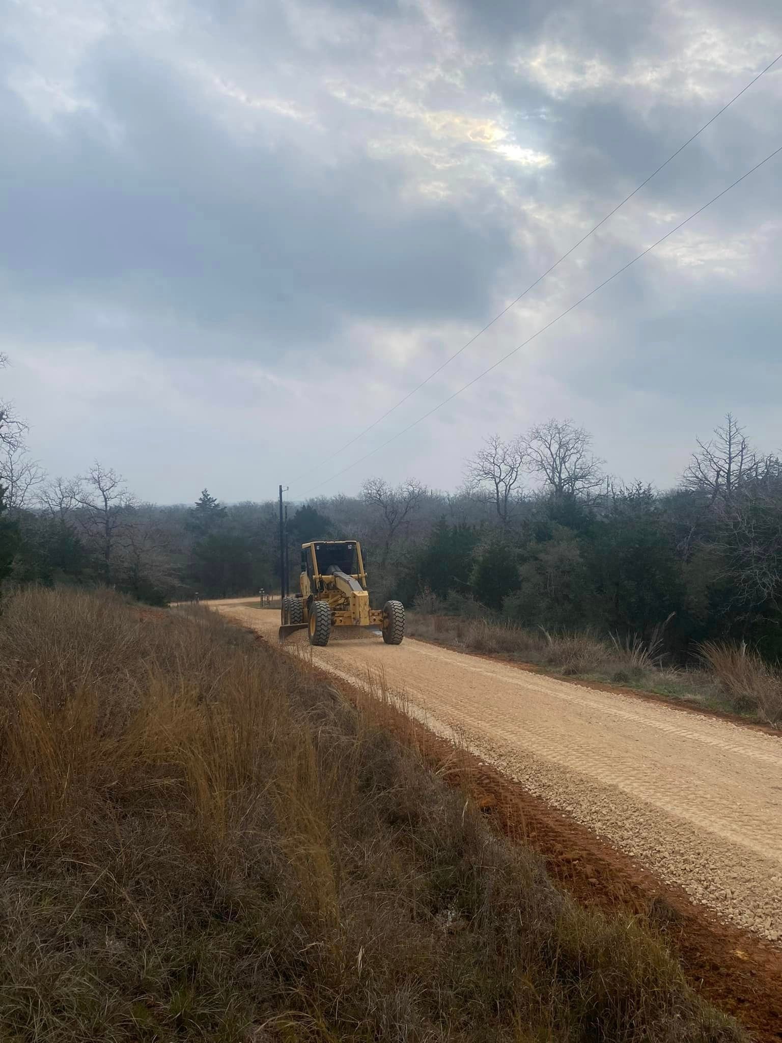 A bulldozer is driving down a dirt road.