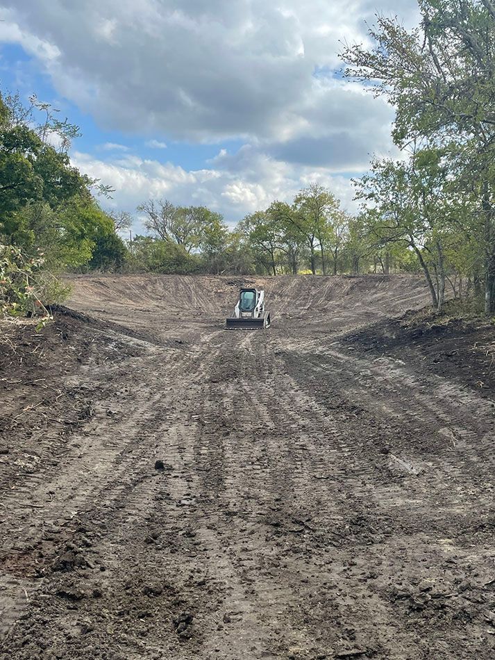 A bulldozer is driving down a dirt road.