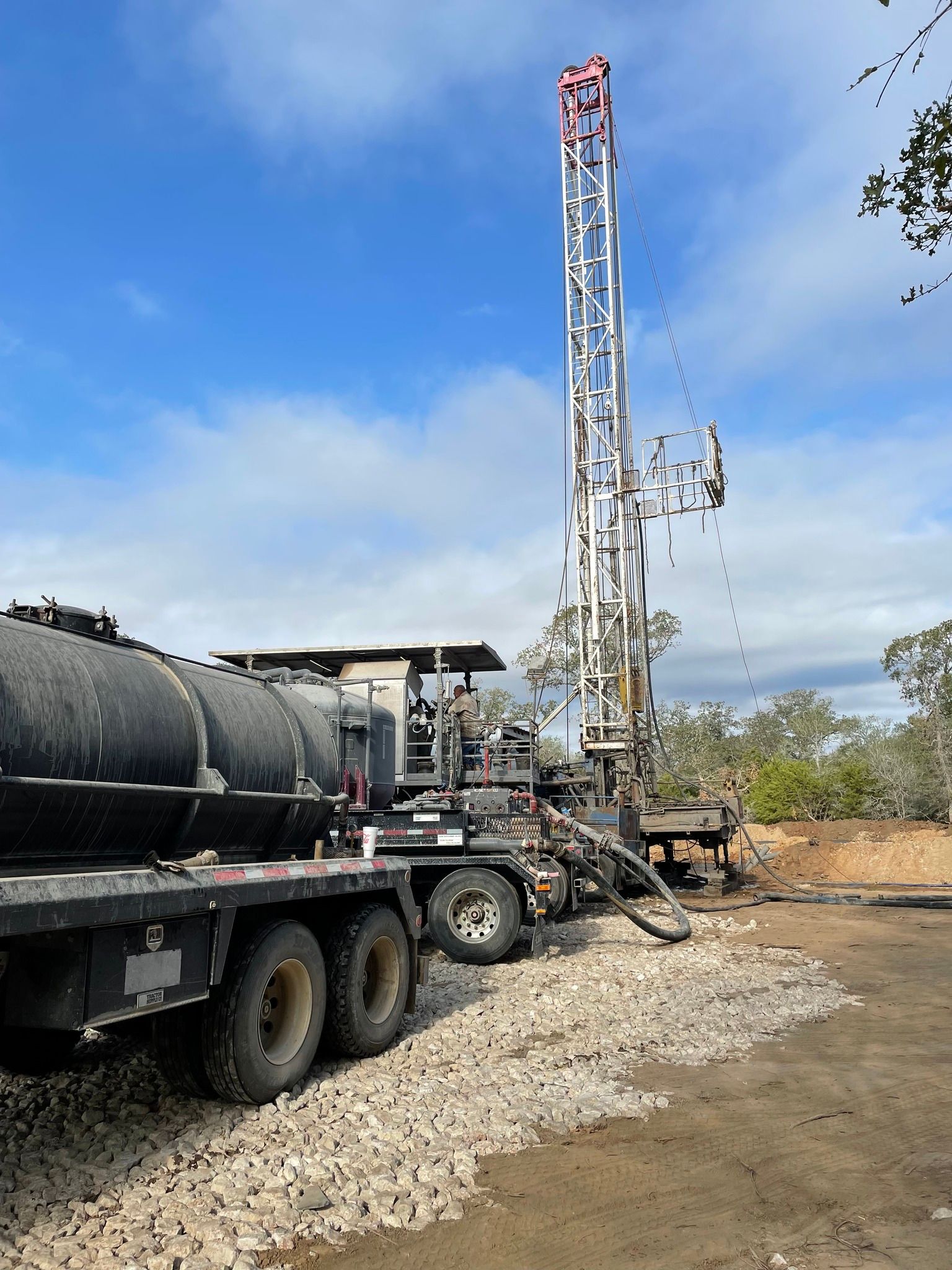 A truck is parked in front of a drilling rig.