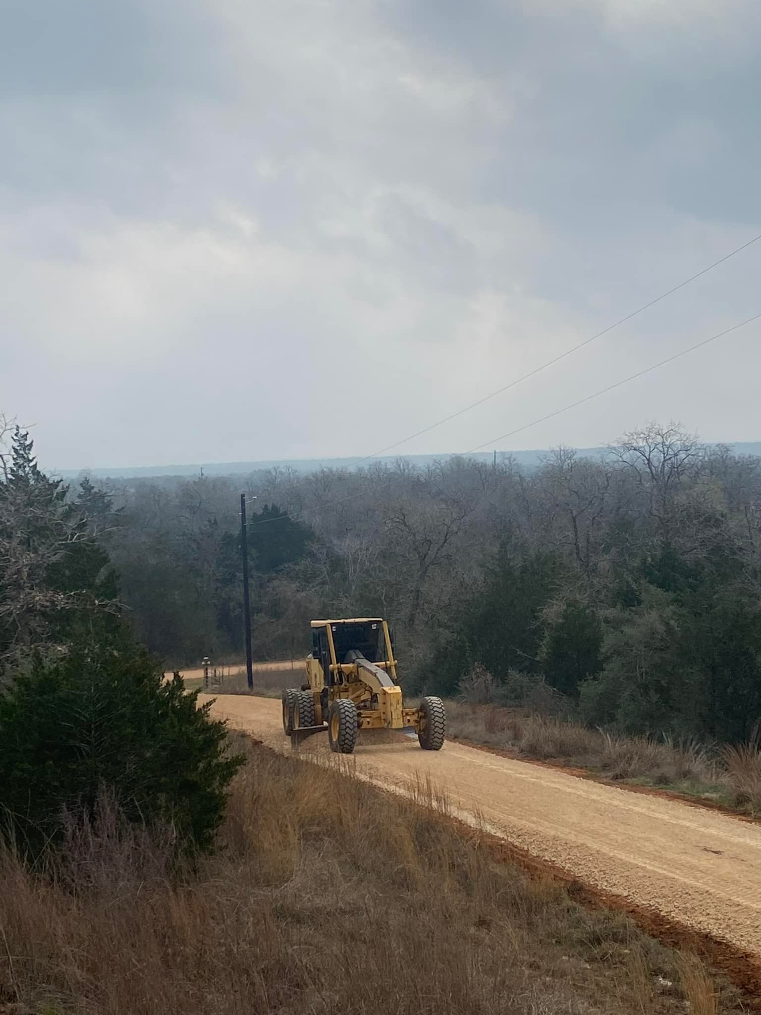 A bulldozer is driving down a dirt road.