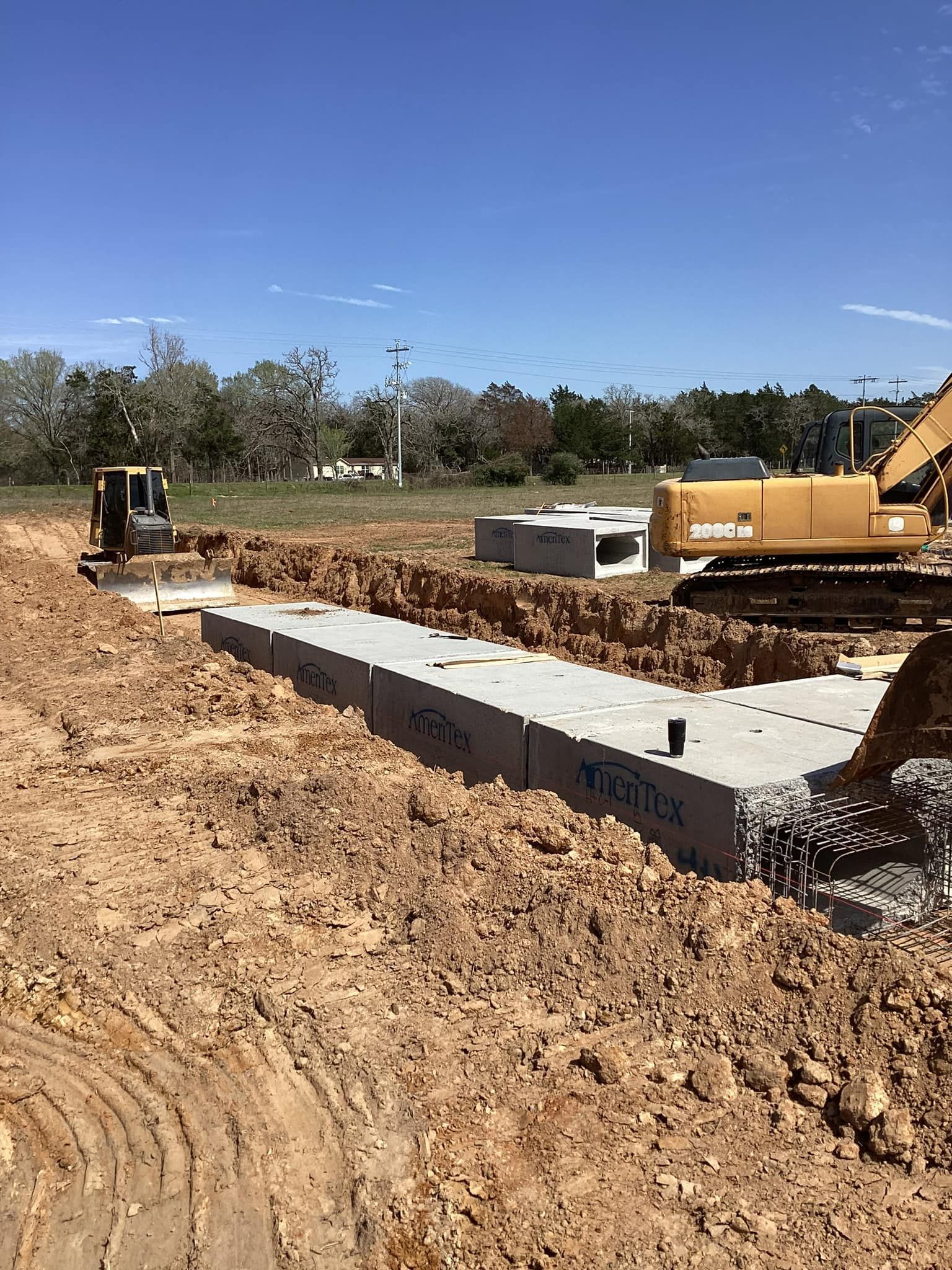 A bulldozer is digging a hole in the dirt in a construction site.