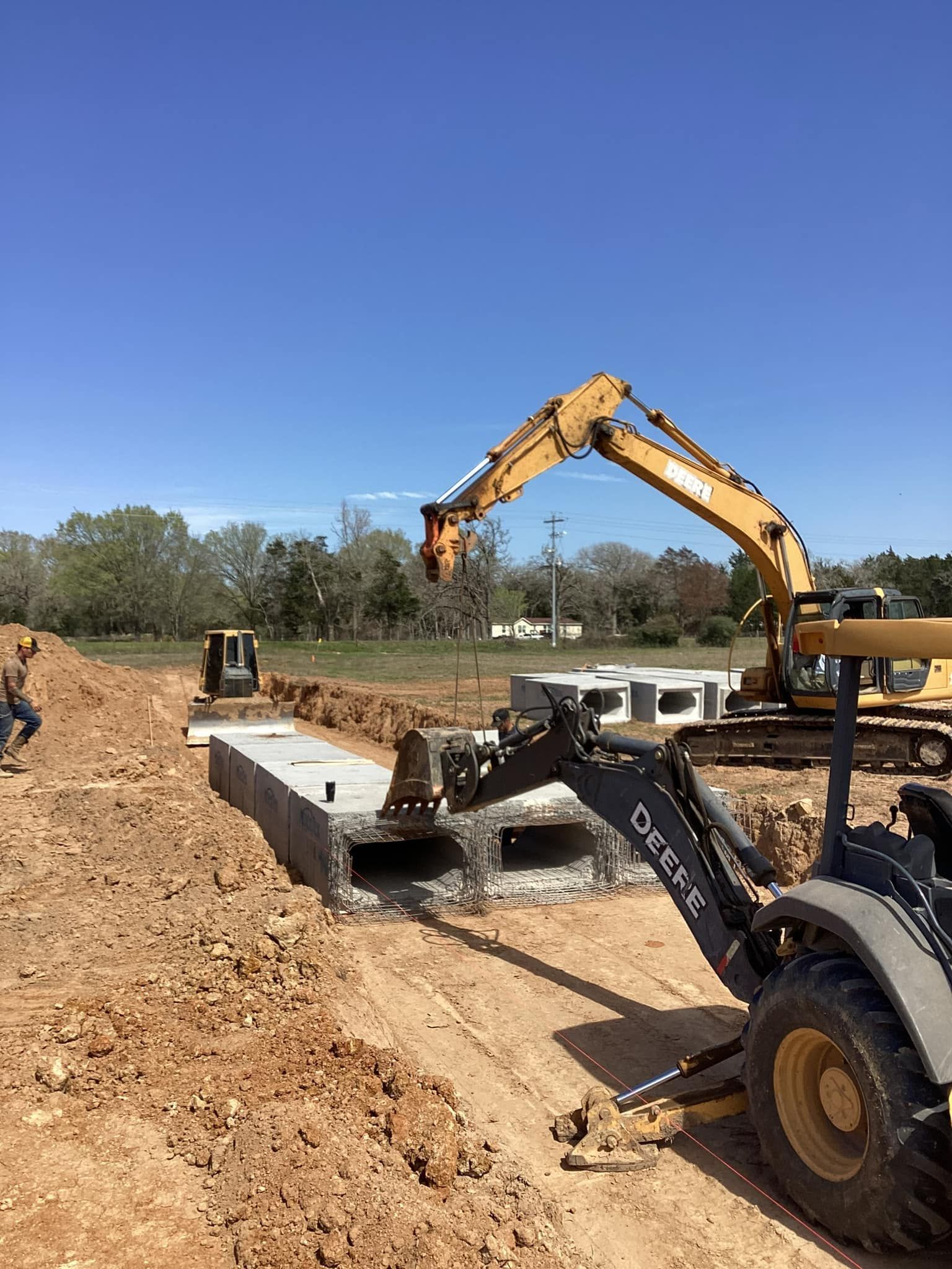 A yellow excavator is digging a hole in the dirt.