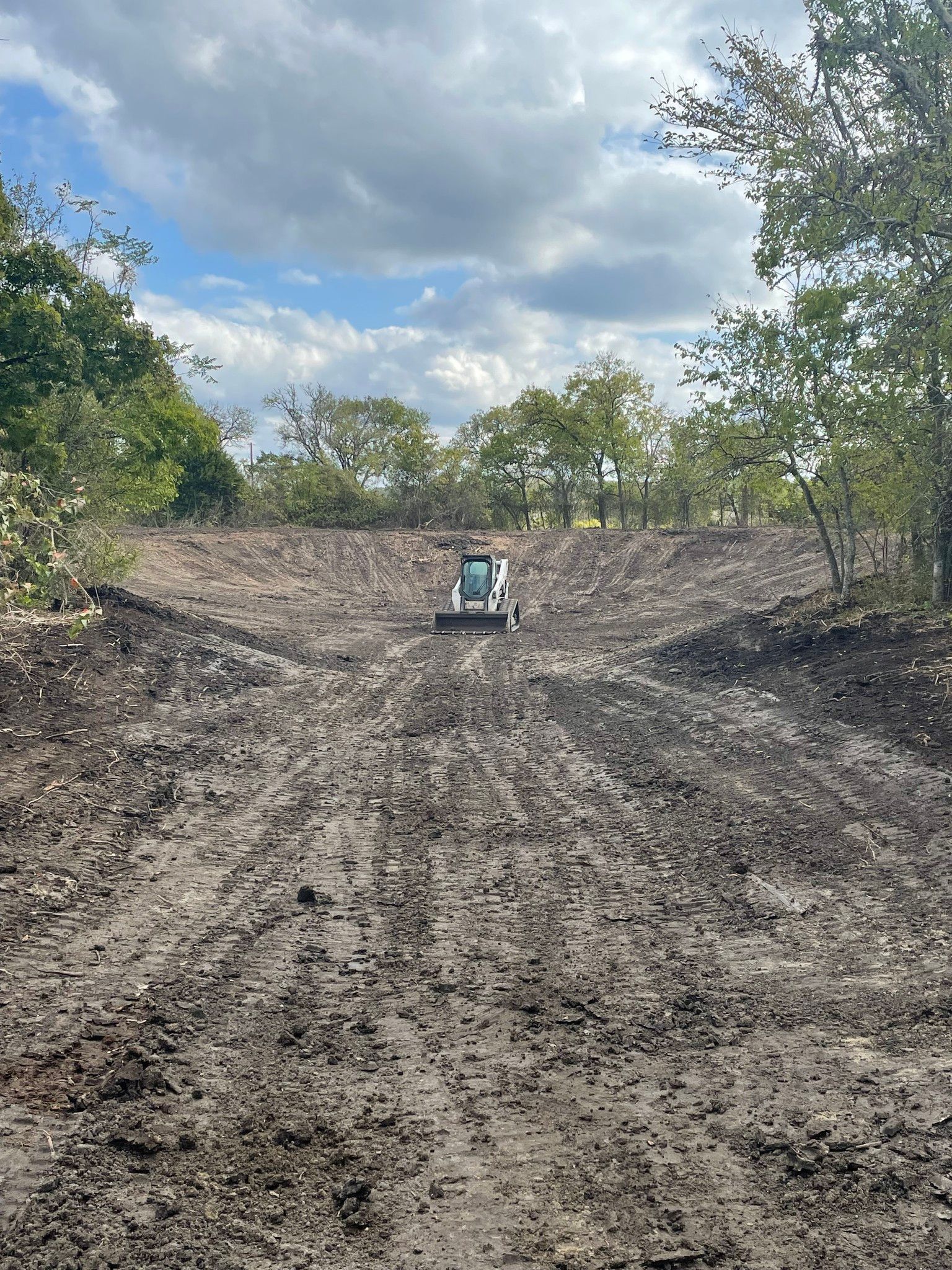 A bulldozer is driving down a dirt road.