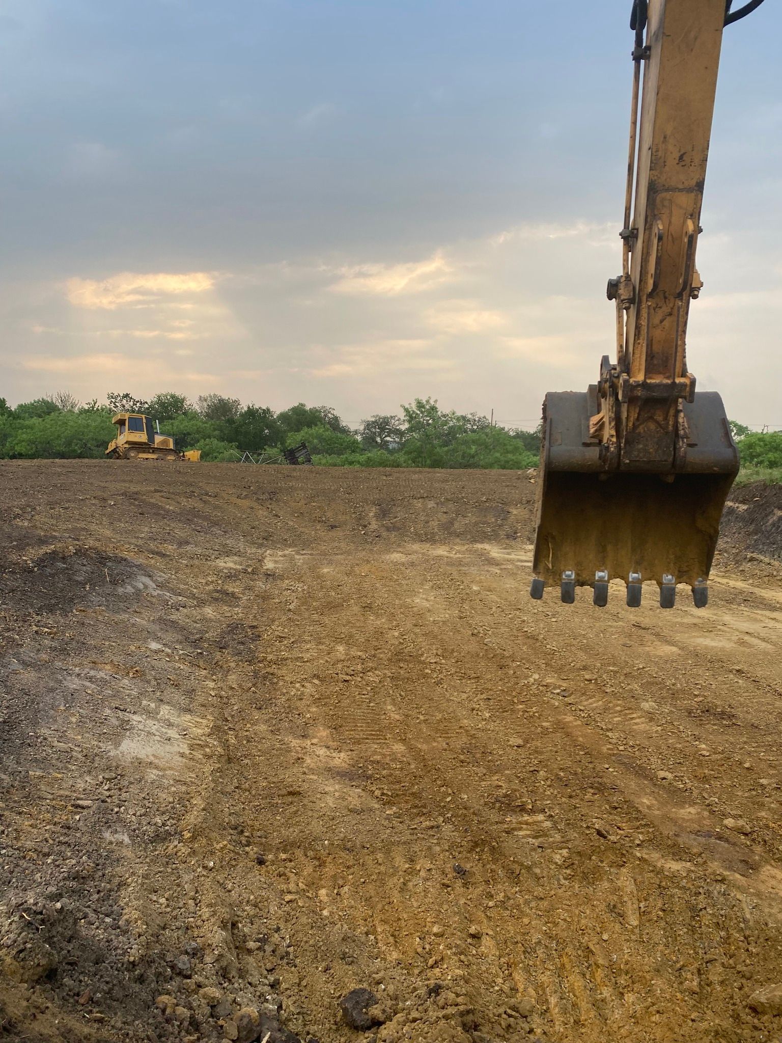 A bulldozer is digging a hole in a dirt field.