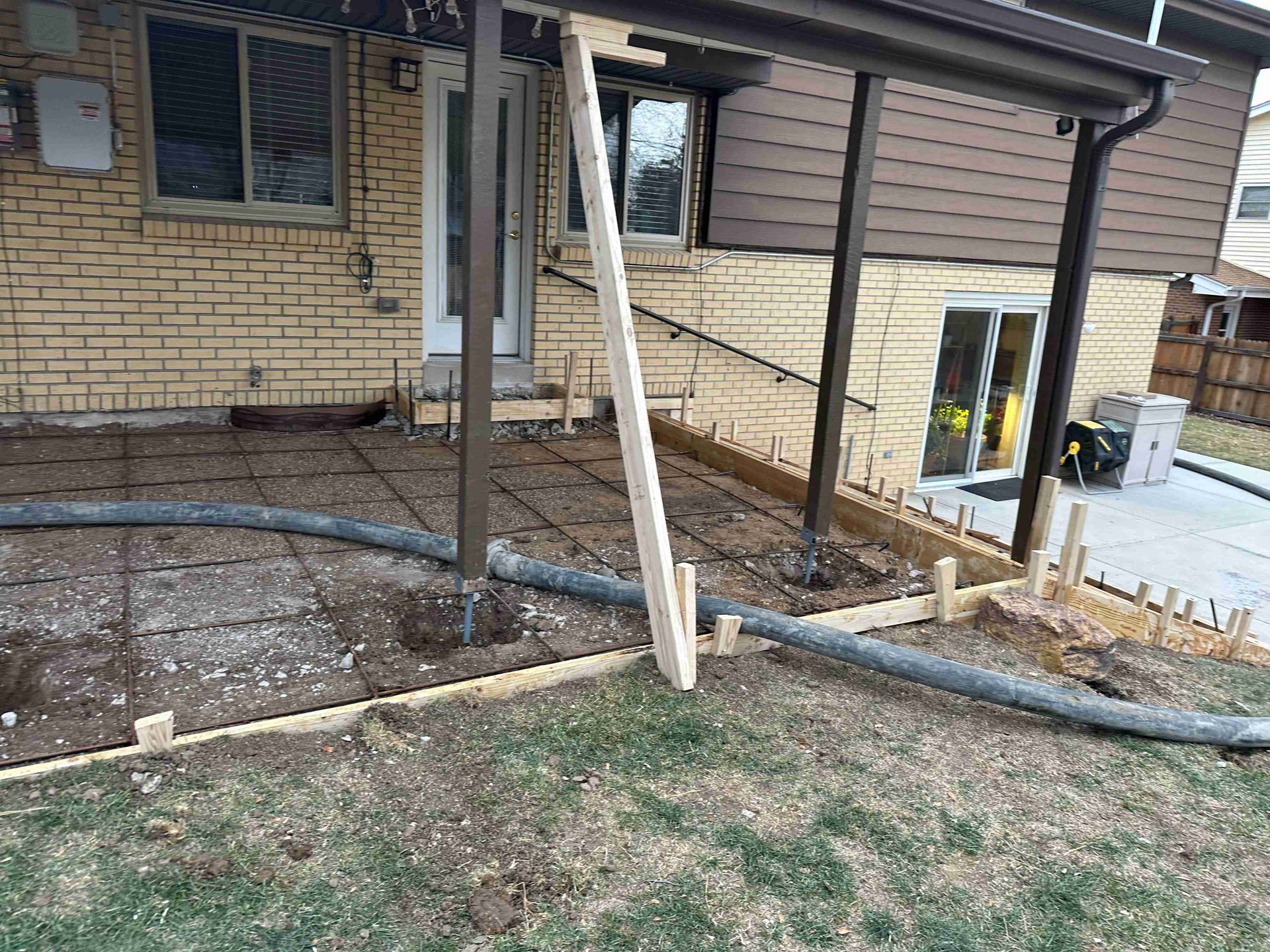 House exterior with damaged porch supports and exposed foundation work area
