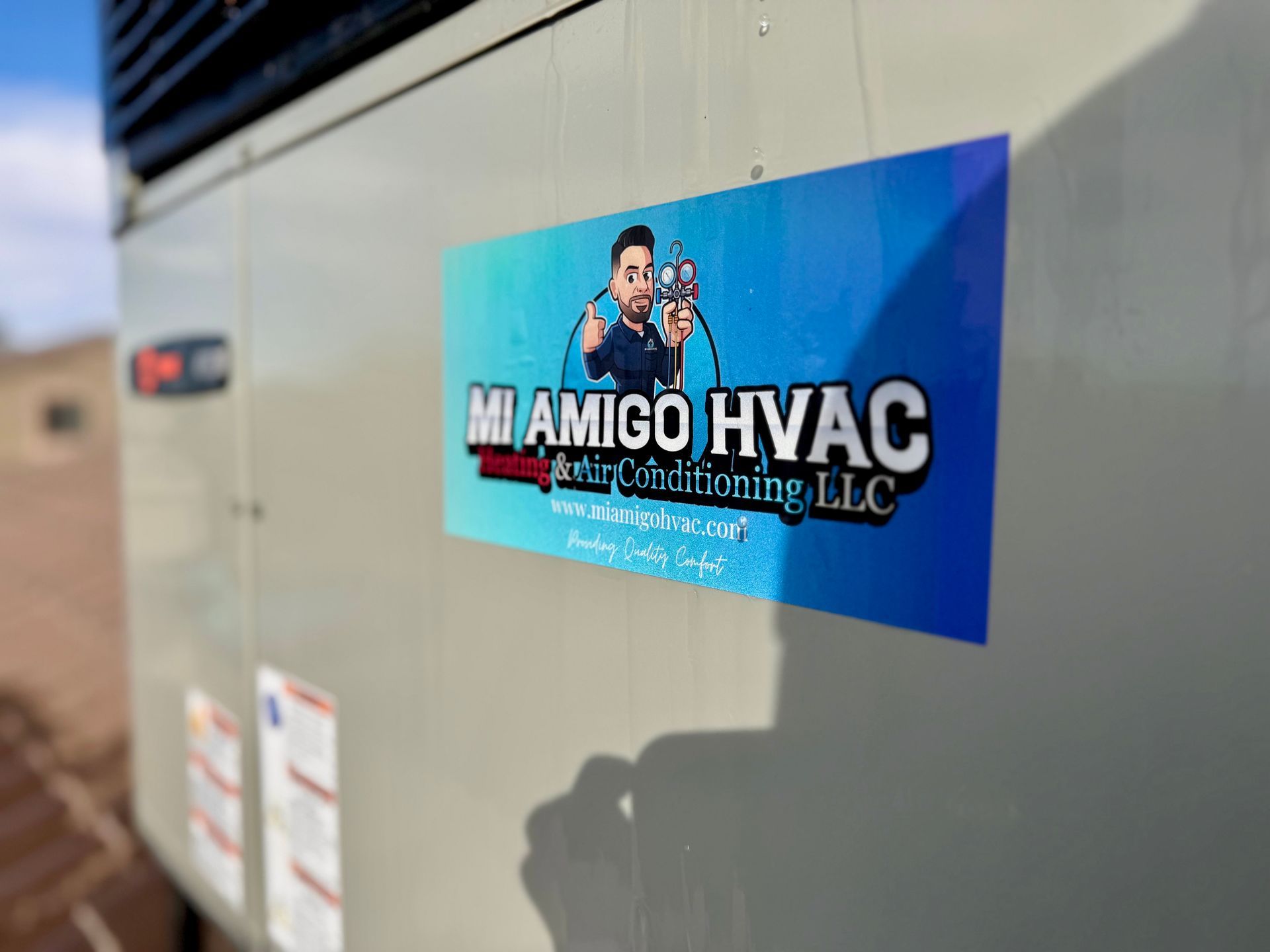 A rectangular blue sticker on an HVAC unit, featuring the text 