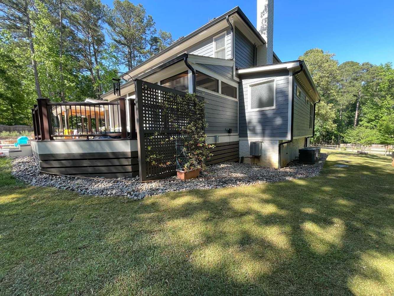 A house with a deck and a fence in the backyard.