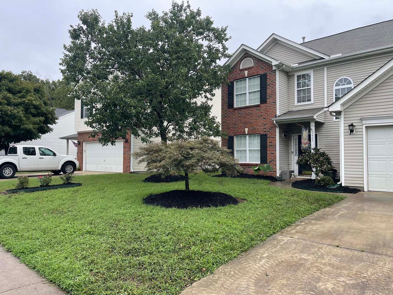 A brick house with a white truck parked in front of it.