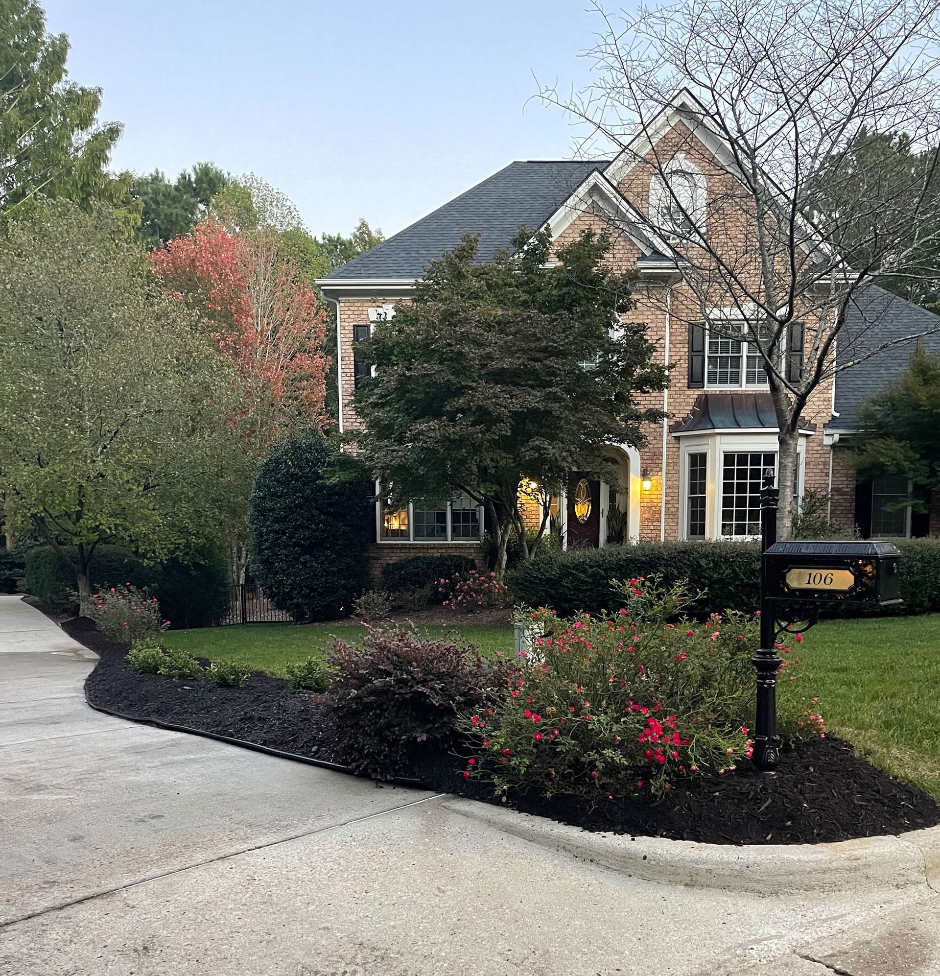 A large brick house with a mailbox in front of it