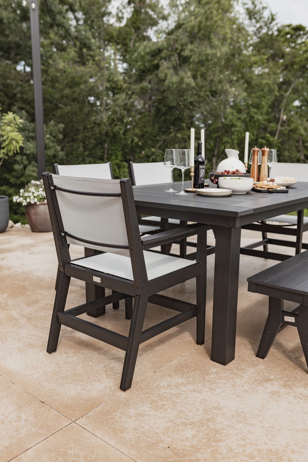 Mayhew Sling dining arm chairs around outdoor table on patio.