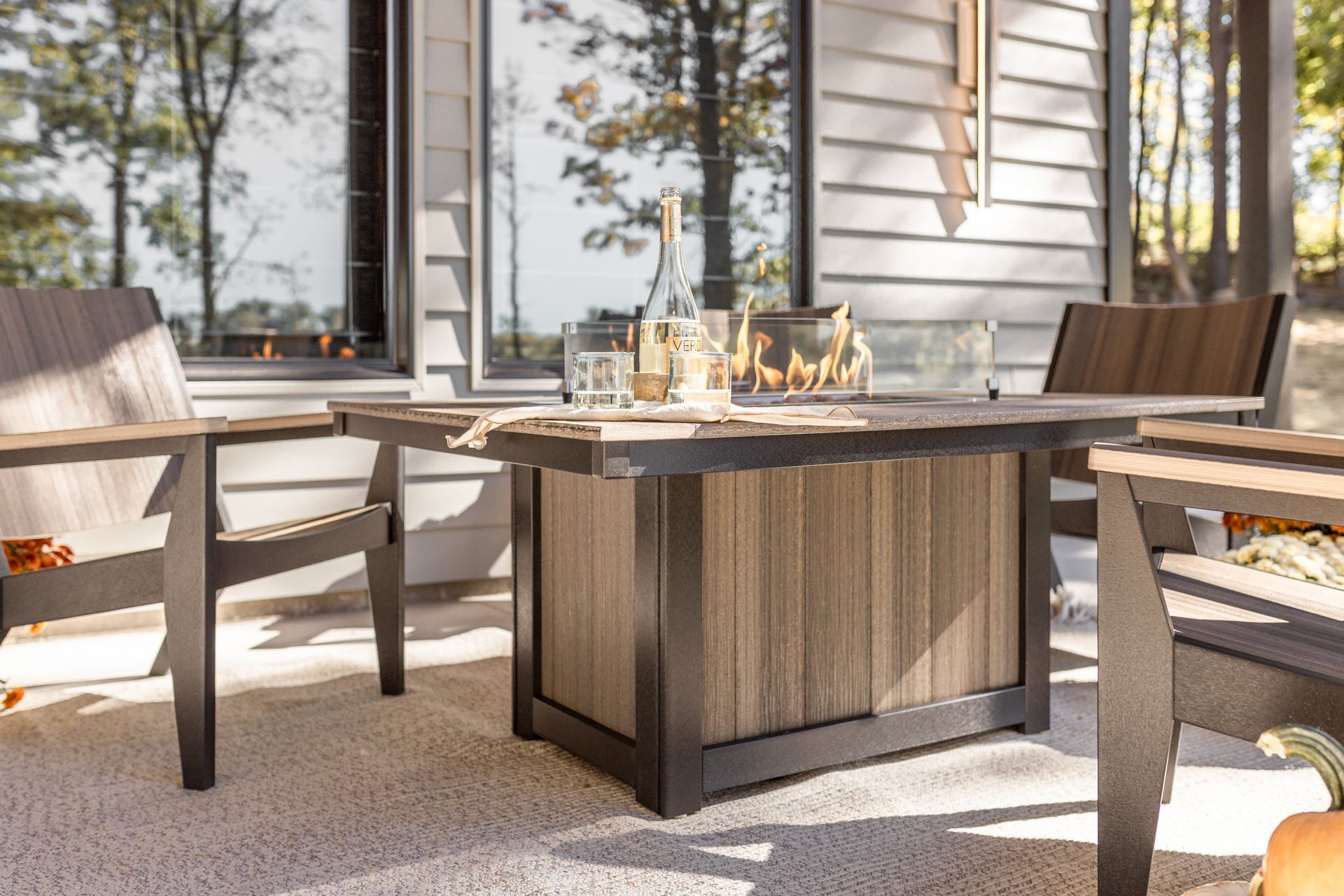 Donoma rectangular fire pit with Mayhew Chat Chairs arranged on an outdoor patio for cozy evenings