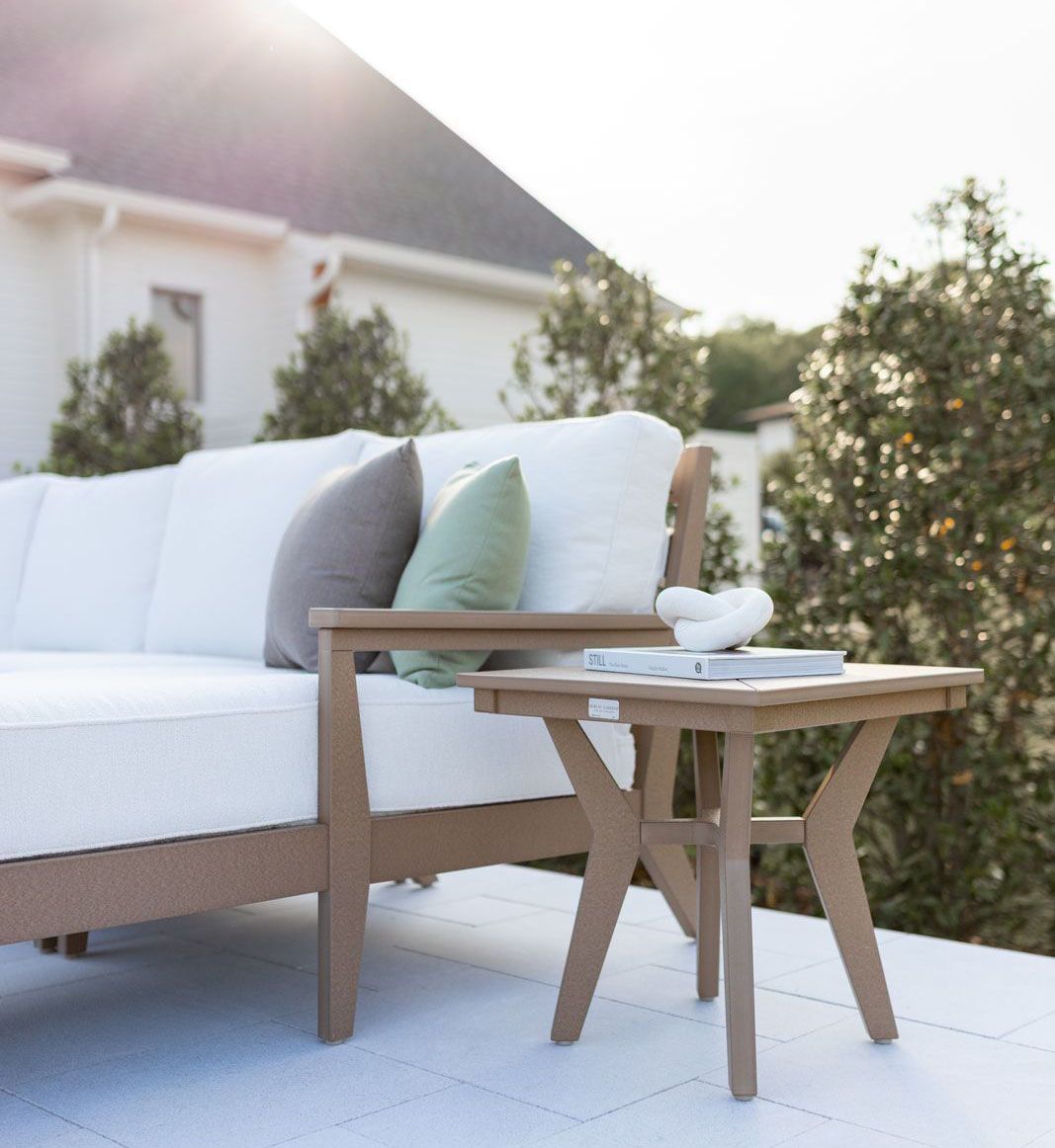 Outdoor seating area with a white sectional sofa and a side table.