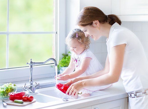 Mother and daughter by the sink