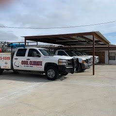 White company trucks parked under a covered structure.