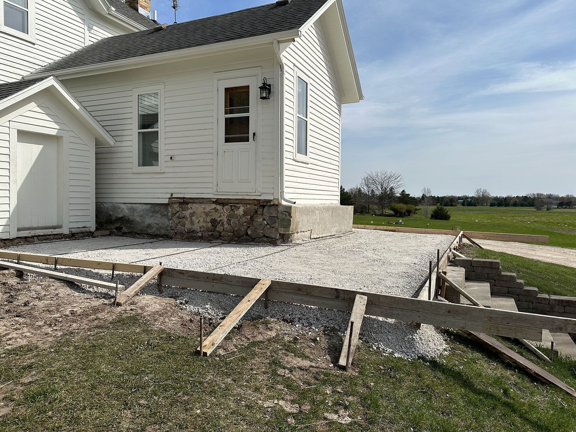 A white house is being remodeled in a rural area