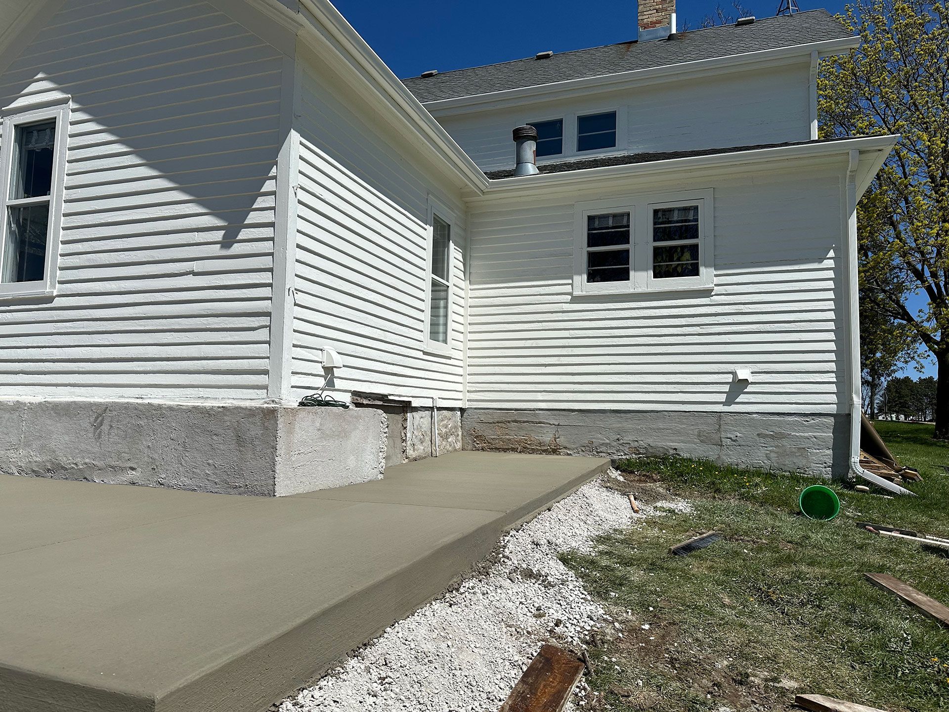 A white house with a concrete walkway in front of it