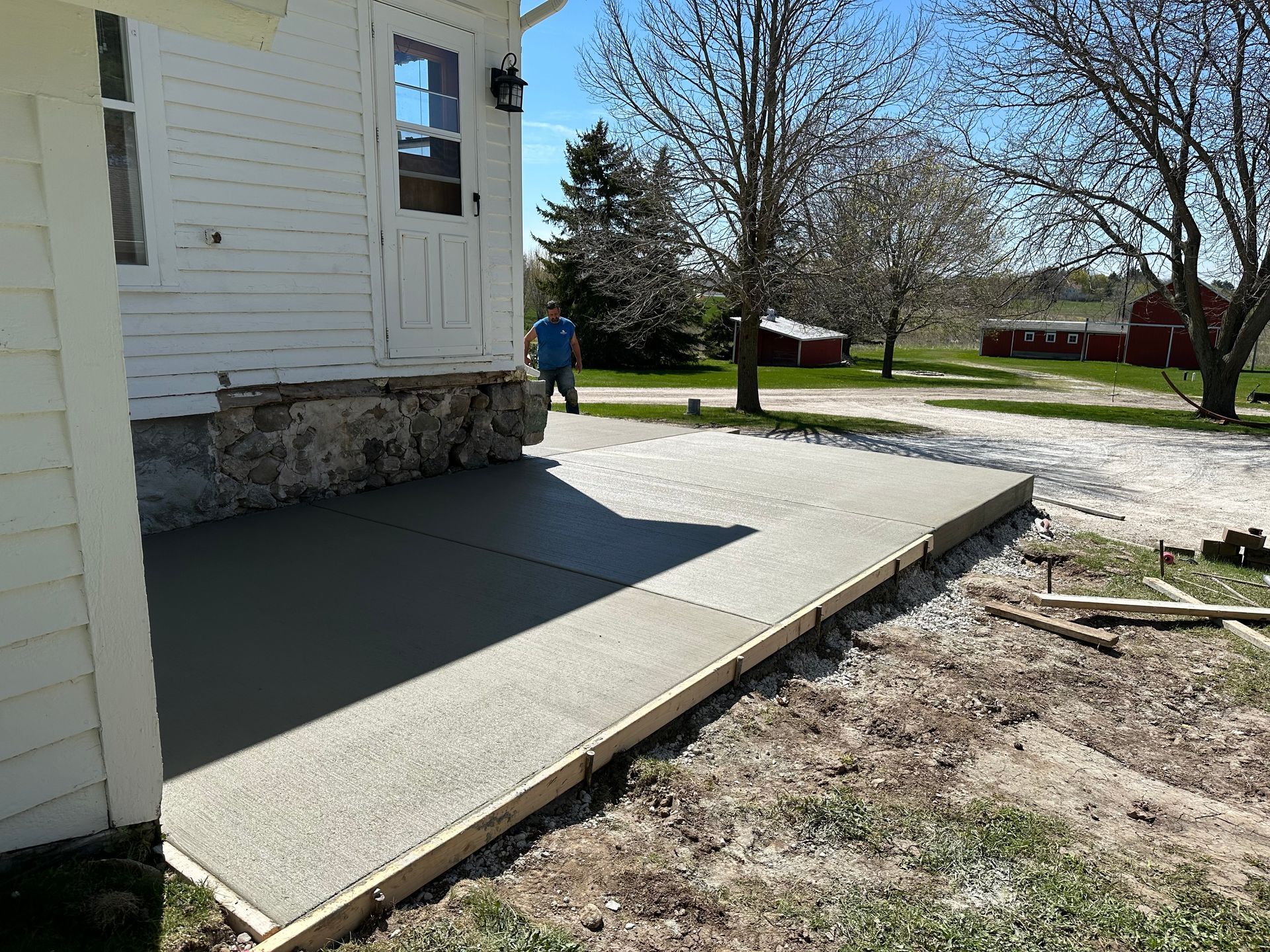 A concrete walkway is being built in front of a white house