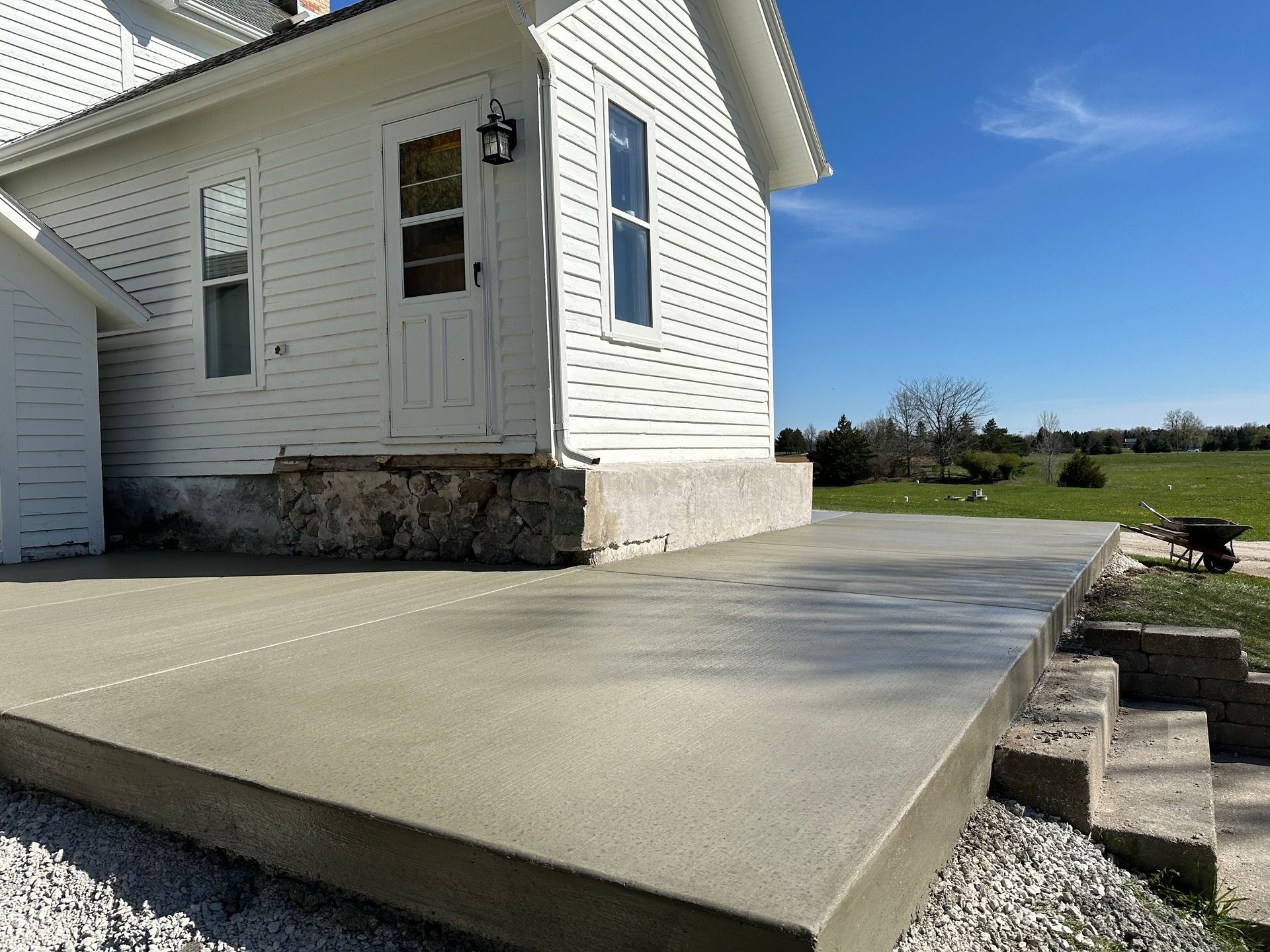 A white house with a concrete walkway in front of it