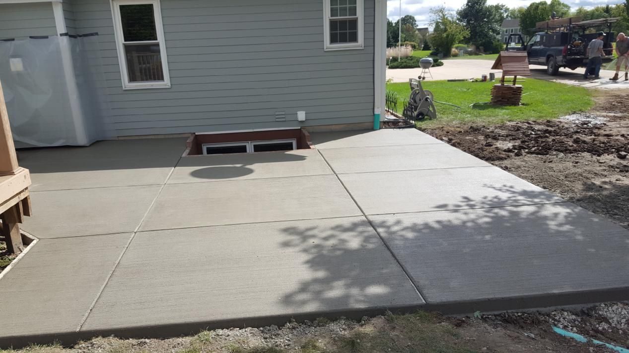 a newly-built concrete patio in front of a house