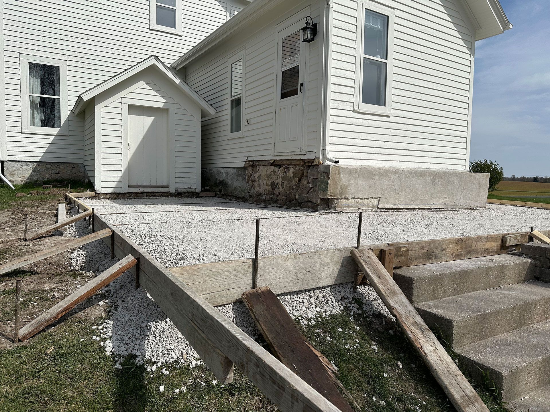 A white house with stairs being built in front of it
