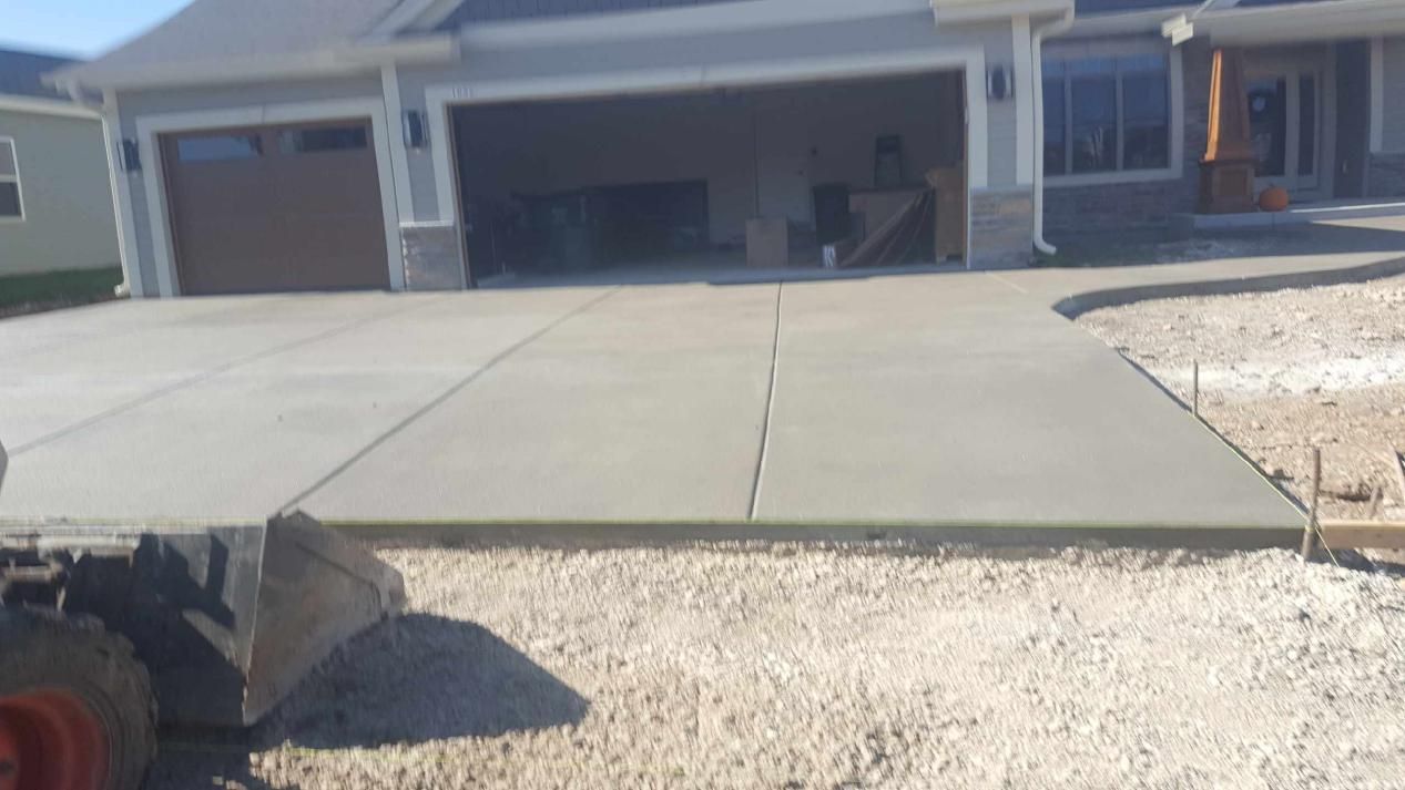 a concrete driveway is being built in front of a huge garage