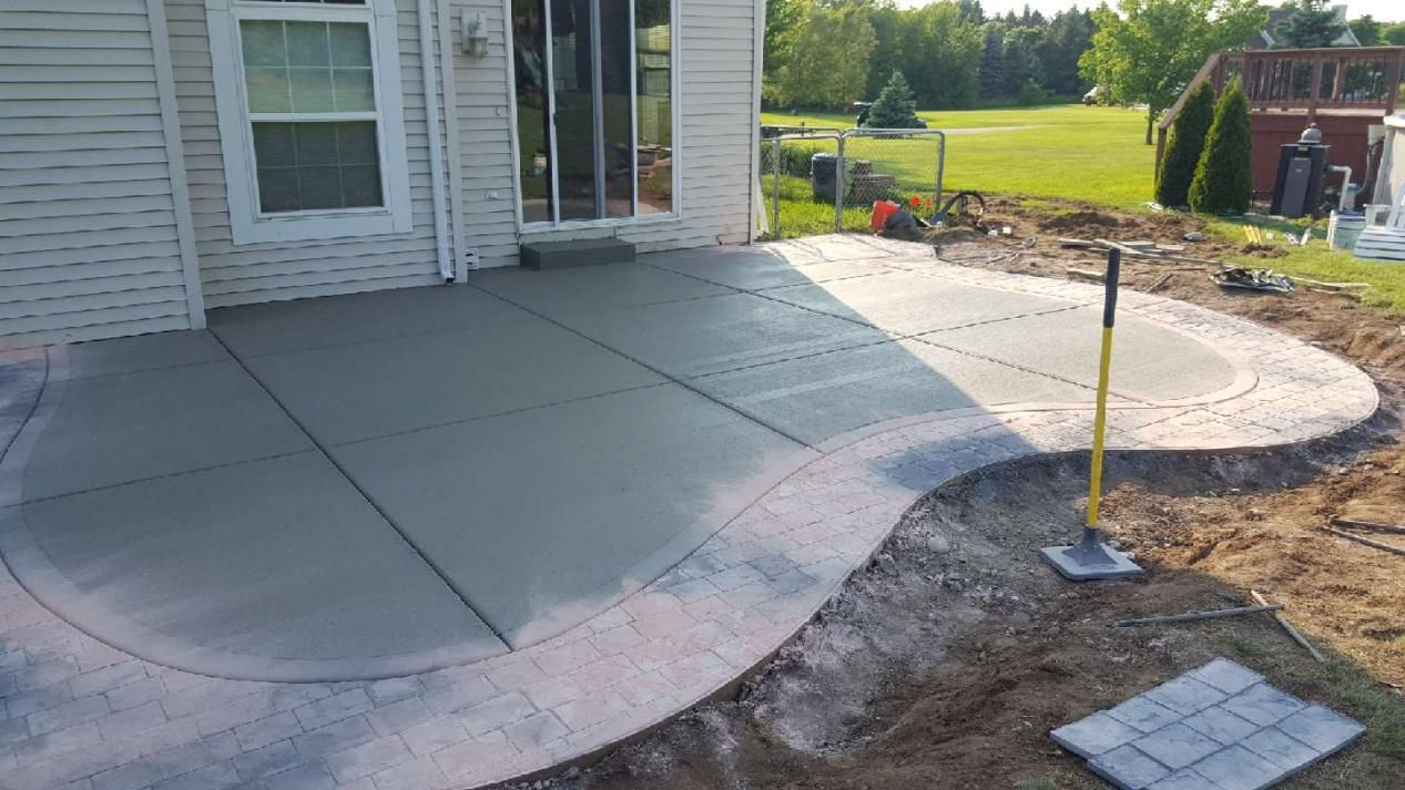 a custom-shaped concrete patio is being built in front of a house