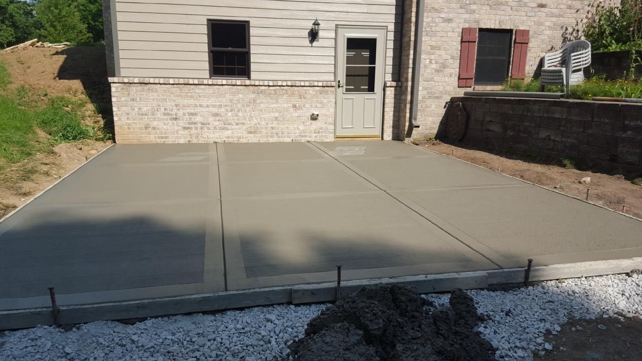 a concrete patio is being built at the back of the house