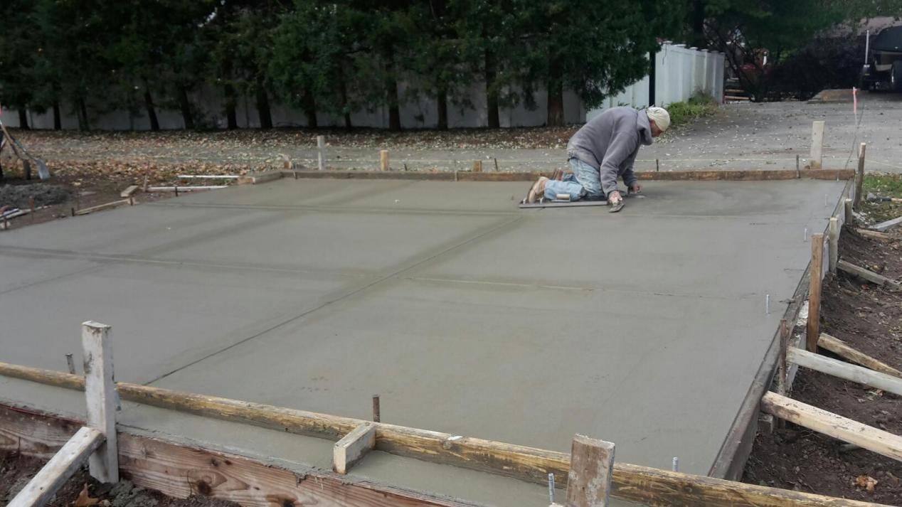 a man is kneeling down on a concrete surface