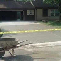 a wheelbarrow is parked in front of a house with a newly-built driveway