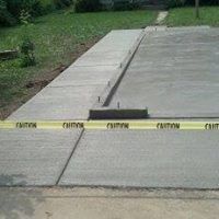 a concrete patio with a yellow caution tape