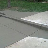a concrete sidewalk with a curb and grass in the background