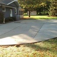 a shaded concrete driveway in front of a house