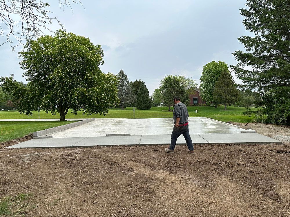 A man is walking on a concrete driveway in a park.