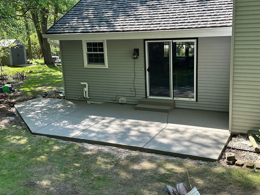 A concrete patio is being built in front of a house.