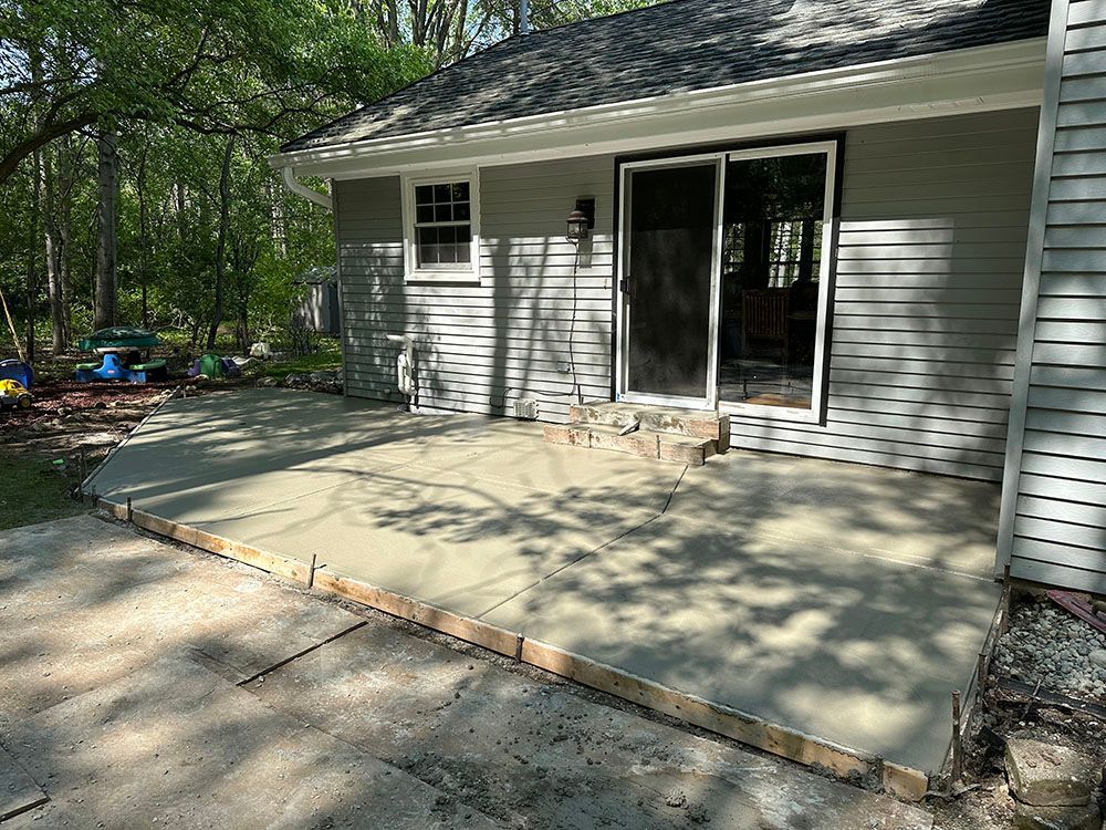 A concrete patio is being built in front of a house.