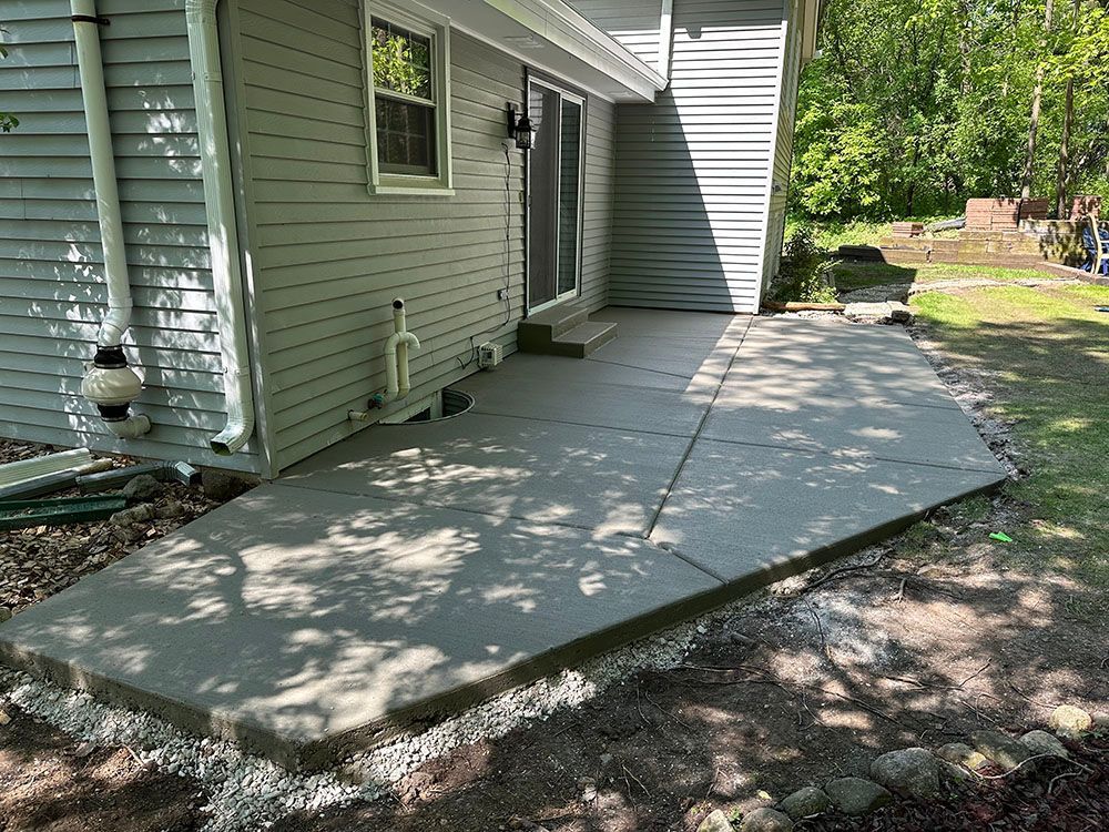 A concrete patio is being built in front of a house.