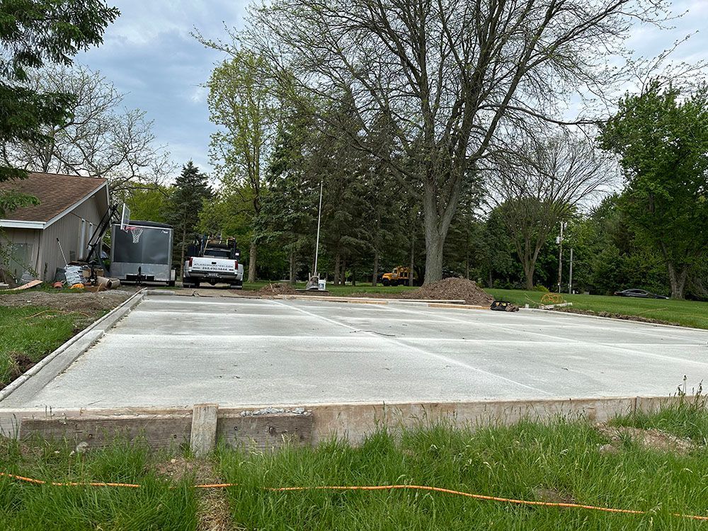 A concrete driveway is being built in front of a house.