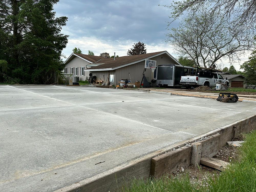 A concrete driveway is being built in front of a house.