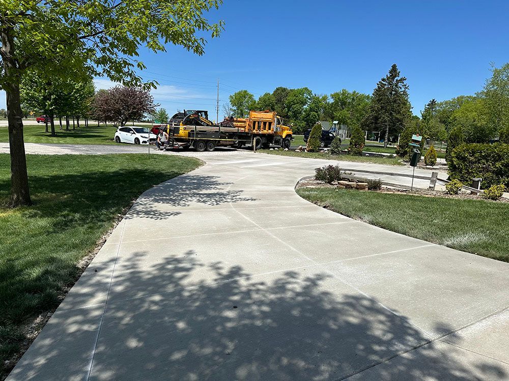 A concrete driveway with a truck parked on the side of it.