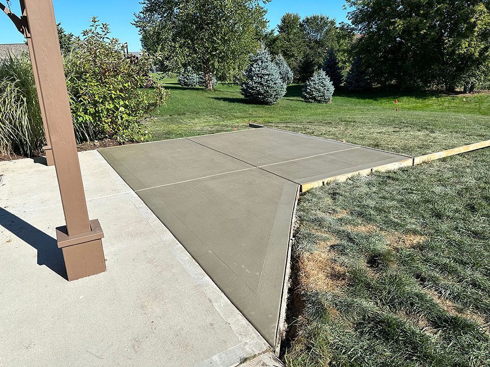 A concrete walkway is being built in a backyard.
