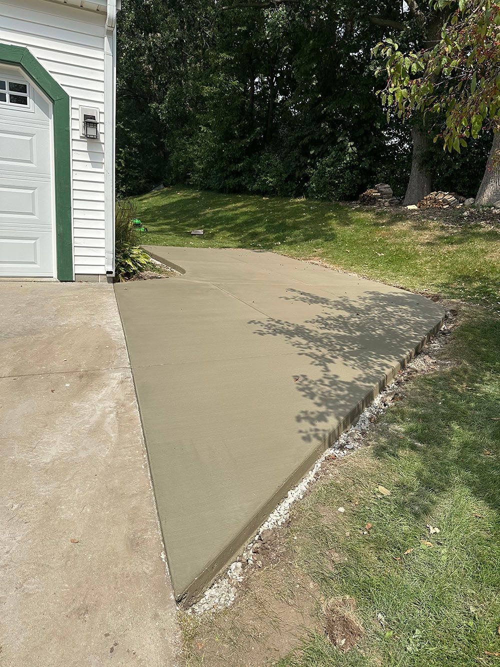 A concrete driveway is being built in front of a garage.