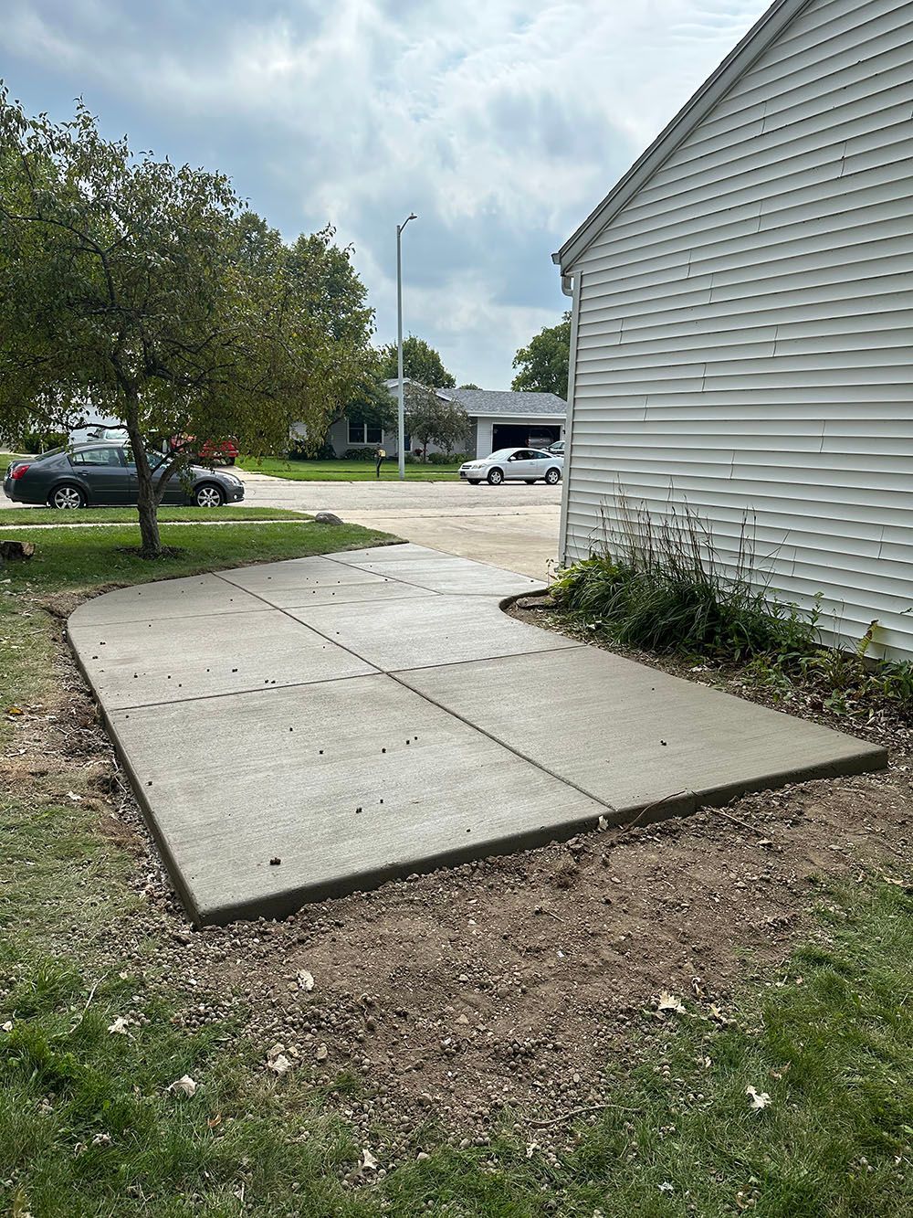A concrete driveway is being built in front of a house.