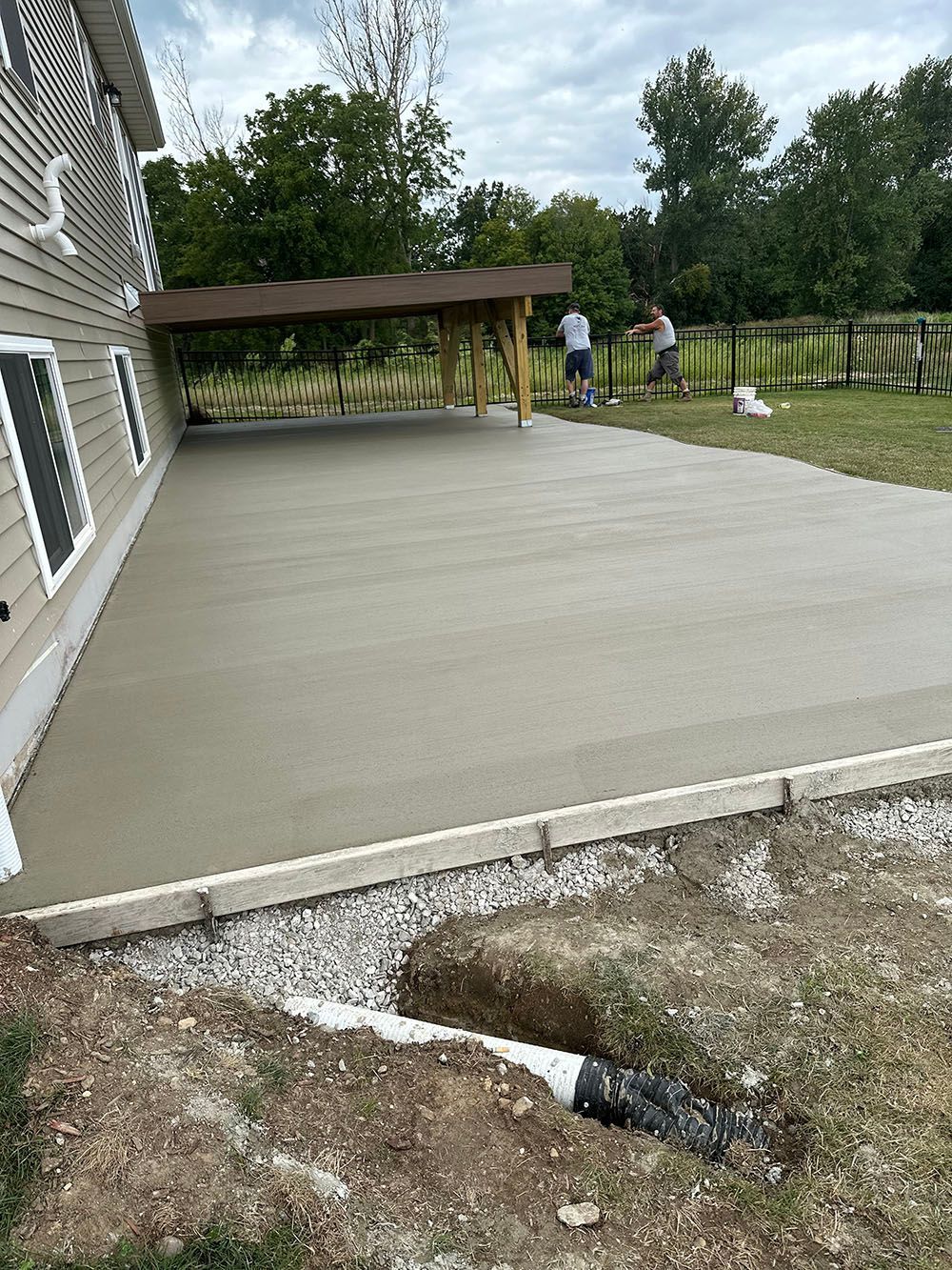 A concrete driveway is being built in front of a house.